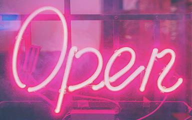 Pink neon open sign with a dark background.