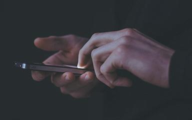 Hands scrolling on a smartphone. 